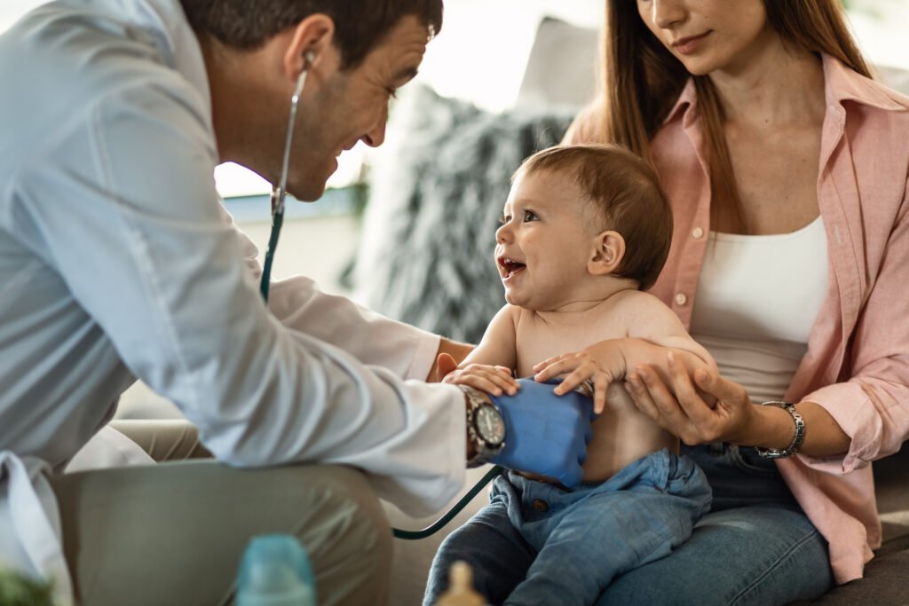 Cute baby boy having fun during medical appointment at pediatrician's.